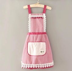 a red and white checkered dress hanging on a clothes rack with a wooden hanger