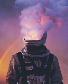 a man wearing a space suit and helmet with a rainbow in the sky behind him