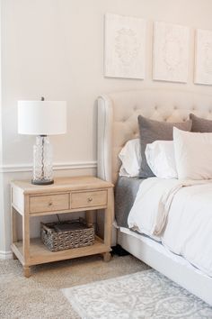 a bedroom with a bed, nightstand and pictures on the wall