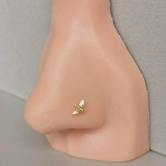 a close up view of a nose with two small gold flowers on it's side