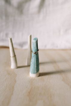 three small ceramic cones sitting on top of a wooden table