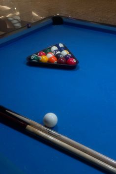 a pool table with a billiards and cues on it, ready to be played