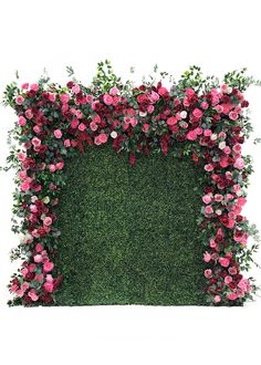 a green wall with pink flowers and greenery in the shape of a square frame