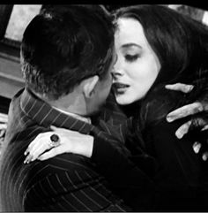 a man and woman embracing each other in black and white