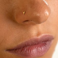 a woman's nose with a tiny gold star piercing on the tip of her nose