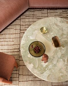 a table with a bowl on it in the middle of a room next to a couch