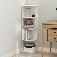 a corner shelf with books and other items on it next to a nightstand in a white room