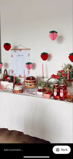 a table topped with cakes and desserts on top of a white tablecloth covered table