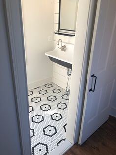 an open door leading to a bathroom with black and white tile