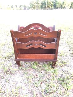 an old wooden bed frame sitting in the grass