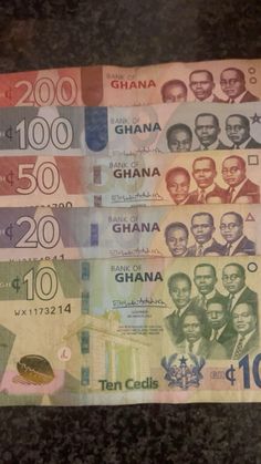 several different types of african money are on the counter top in front of a black background