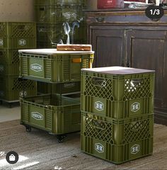 three green crates sitting next to each other on top of a rug in front of a dresser