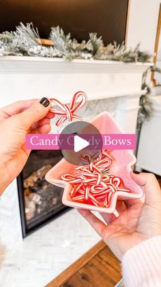 a person holding up some candy canes in front of a fireplace with the words candy city bows on it