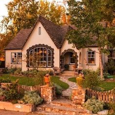 a house with lots of plants and trees around it