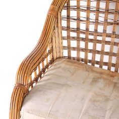 a wicker chair with a cushion on it's back and seat padding