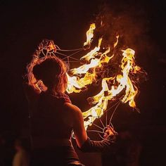 a woman standing in front of a fire ball