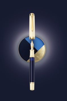 a blue and gold fountain pen sitting on top of a circular object