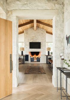 a living room filled with furniture and a fire place next to a wall mounted tv