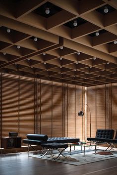 an empty room with two black leather chairs and a table in front of the window