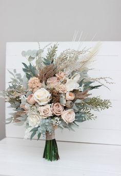 a bouquet of flowers sitting on top of a white table next to a wooden wall