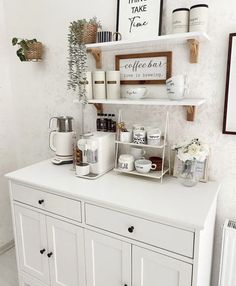 a white coffee bar with shelves and cups on it