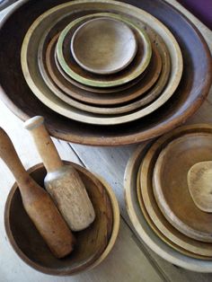 wooden bowls and spoons are stacked on top of each other