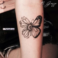 a black and white butterfly tattoo on the right arm, with a daisy in it's center