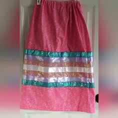 a pink skirt with multi - colored sequins hanging on a door hanger