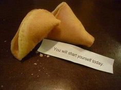 two fortune cookies sitting on top of a table next to a piece of paper that says, you will start yourself today