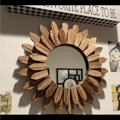 a mirror that is on the wall with pictures around it and a sunflower in the middle