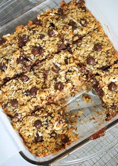 an oatmeal and chocolate chip dessert in a glass dish on a cooling rack