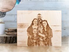 a family photo engraved on a wood block with the image of two adults and one child