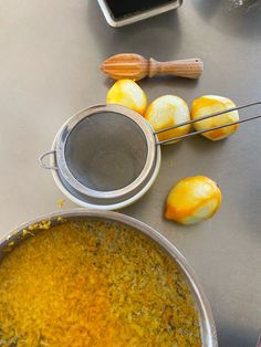 there are some peeled lemons on the table next to a strainer and spatula