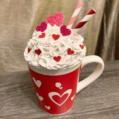 a cup filled with whipped cream and hearts