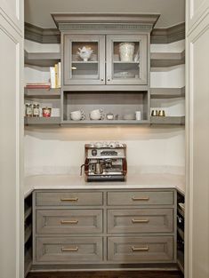 a kitchen with gray cabinets and white counter tops