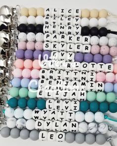 several bracelets that have different types of beads and letters on them, all in different colors