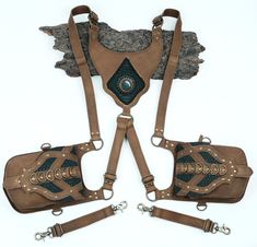 three pieces of leather with chains and buckles attached to each other on a white background