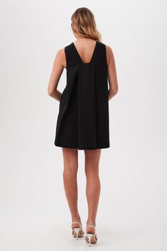 This sleeveless shift dress offers a timeless A-line silhouette with a short cocktail length, a round neckline, and an inverted back pleat for an elegant finish. Round neckline V-back Decorative, jeweled neckline Sleeveless Inverted back pleat Side zipper A-line silhouette Length: 37" Runs true to size Model is 5'10", wearing size 2 See Women's Size Guide FABRIC: Luxe Drape Suiting 63% Polyester, 32% Viscose, 5% Spandex Machine or hand wash cold Imported A-line Sleeveless Dress With Back Zipper For Work, Black Sleeveless Knee-length Dress With Back Zipper, Black A-line Sleeveless Pleated Dress, Shift V-neck Dress With Notched Neckline, Black A-line Shift Dress, Jewel Neckline, Sleeveless Shift Dress, Trina Turk, Black Shorts