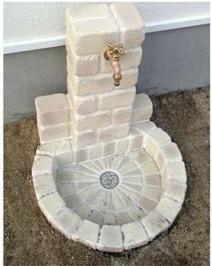 a fountain made out of bricks with a door on the top and handle in the middle