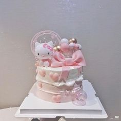 a hello kitty cake with pink and white decorations