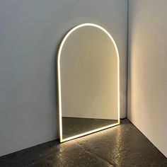 a white room with an arch shaped mirror in the corner and light coming through it