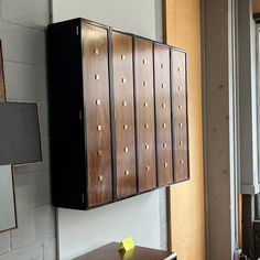 a wall mounted cabinet next to a window