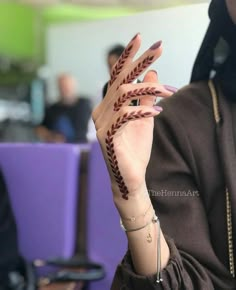 a woman holding up her hand with a tattoo on it's palm and fingers