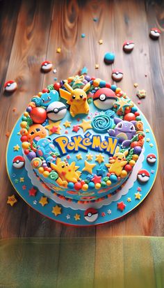 a pokemon themed birthday cake on top of a wooden table with sprinkles