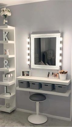 a white vanity with lights on it and a mirror in the corner next to it