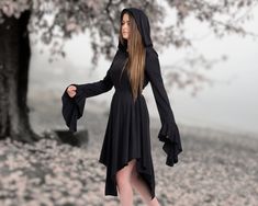 Step into an enchanting realm of style and sophistication with our meticulously crafted Black Hooded Witch Gothic Dress. Designed with a touch of dark allure and a dash of Renaissance inspiration, this dress is bound to make you the center of attention wherever you go. Here's why our dress deserves a place in your wardrobe: ✓ Unveil Your Elegance: Draped in the richness of black, this dress exudes an air of nobility that complements your personality. The captivating asymmetrical design, coupled Gothic Dresses For Halloween Fantasy Events, Black Gothic Dress For Fantasy Events, Black Fantasy Halloween Dresses, Black Dresses For Halloween Fantasy Events, Black Gothic Medieval Dress With Long Sleeves, Black Witchy Dress For Fantasy Events, Fitted Black Dress For Fantasy Events, Gothic Long Sleeve Medieval Dress For Halloween, Gothic Fitted Medieval Dress For Halloween