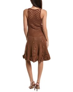 a woman is wearing a brown dress with crochet on the bottom and back