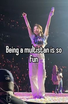 a girl standing on top of a stage with her arms in the air and texting being a multisitan is so fun