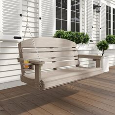 a wooden bench sitting on top of a hard wood floor next to white shutters