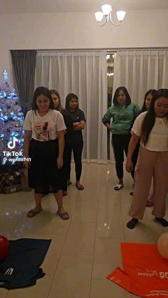 a group of women standing in front of a christmas tree